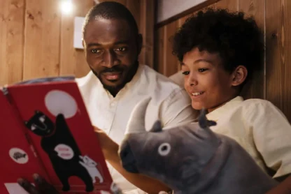 A father reading a children's story to his son, symbolizing Spark & Story’s engaging, educational, and adventure-filled storytelling for young minds.